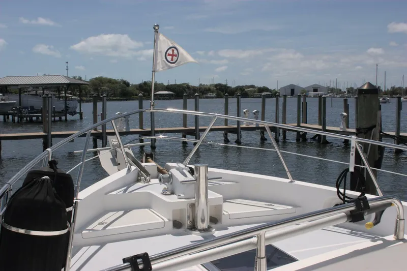 Off The Grid Yacht Photos Pics 2001 Selene Ocean Trawler docked at marina, clear sky, calm water, and flag visible.