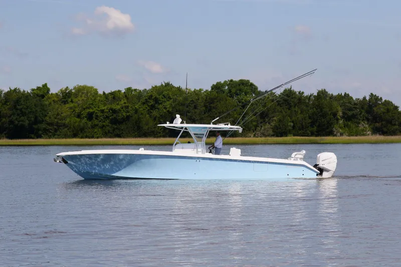  Yacht Photos Pics 2019 Bahama 41 boat cruising on calm water with lush green trees in the background.