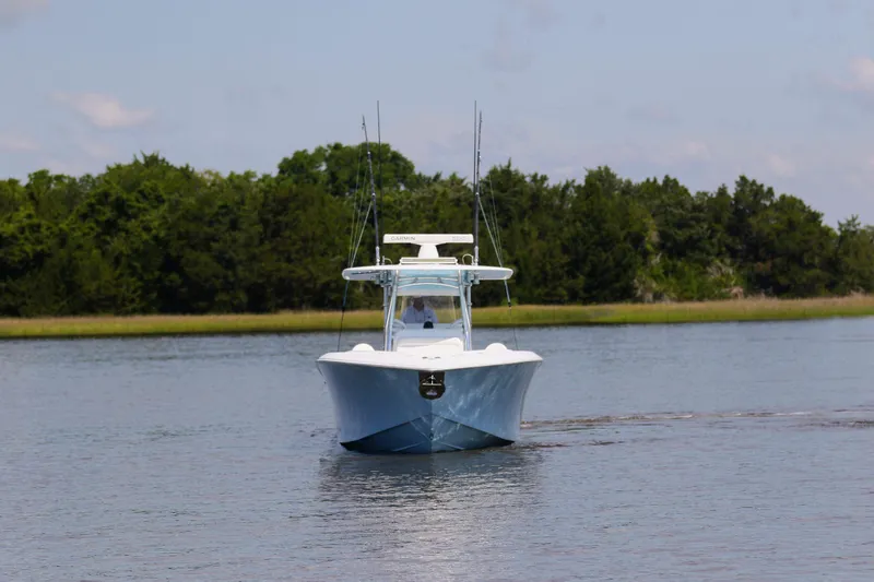  Yacht Photos Pics 2019 Bahama 41 boat cruising on a calm lake with lush green trees.