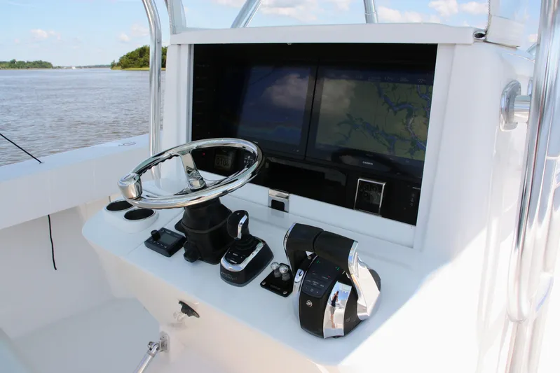  Yacht Photos Pics Control panel of a 2019 Bahama 41 boat with navigation screens and steering wheel.