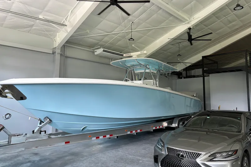  Yacht Photos Pics 2019 Bahama 41 boat in garage with luxury car, showcasing sleek design and modern features.