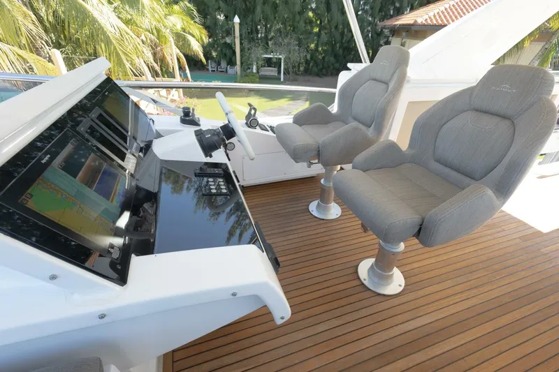 Rho Boat Yacht Photos Pics Flybridge helm of 2021 Azimut Fly 72 yacht with dual seats and navigation controls.