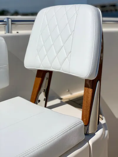  Yacht Photos Pics 2020 Cobia 350 Center Console boat seat with white diamond-stitched upholstery and wooden accents.