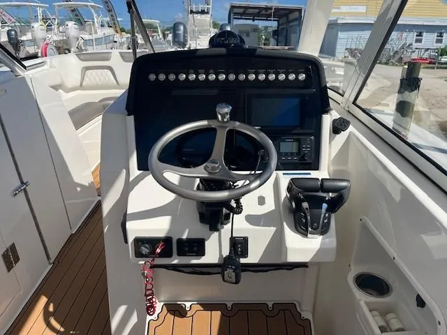  Yacht Photos Pics 2022 World Cat 296 DC boat helm with steering wheel, controls, and navigation screens.