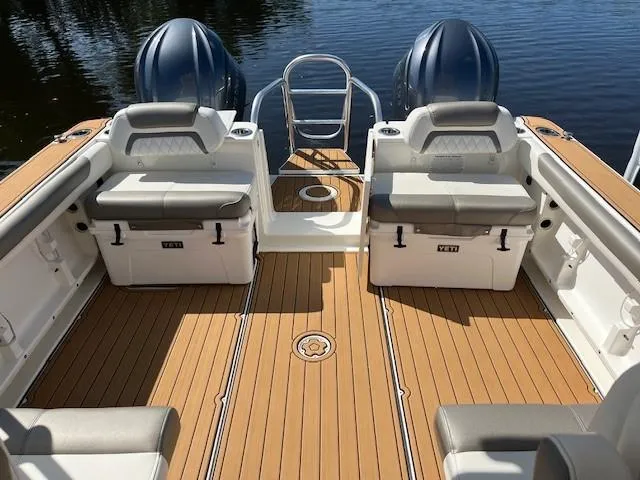  Yacht Photos Pics 2022 World Cat 296 DC boat deck with seating, coolers, and twin engines on calm water.