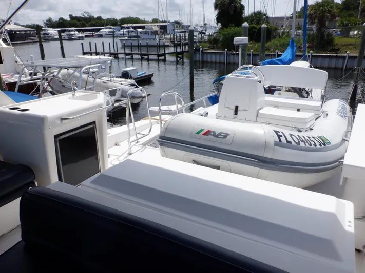 Epic Yacht Photos Pics 1998 Bayliner 4788 Pilothouse Motoryacht with inflatable boat docked at marina.