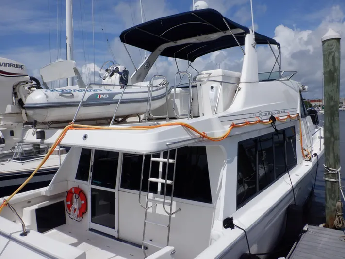 Epic Yacht Photos Pics 1998 Bayliner 4788 Pilothouse Motoryacht docked, featuring upper deck and lifeboat.