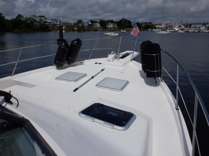 Epic Yacht Photos Pics 1998 Bayliner 4788 Pilothouse Motoryacht deck with hatches and American flag, docked in marina.