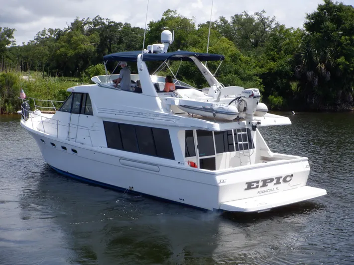 Epic Yacht Photos Pics 1998 Bayliner 4788 Pilothouse Motoryacht cruising on a calm river with lush greenery.
