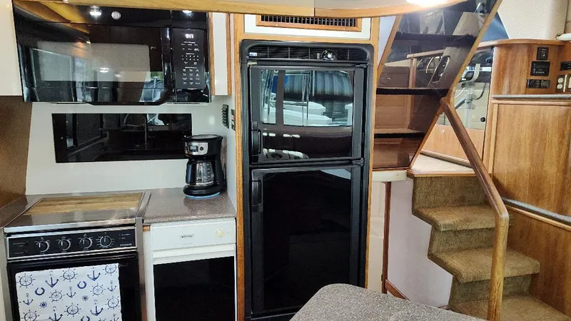 Epic Yacht Photos Pics Interior of 1998 Bayliner 4788 Pilothouse Motoryacht with kitchen appliances and stairs.