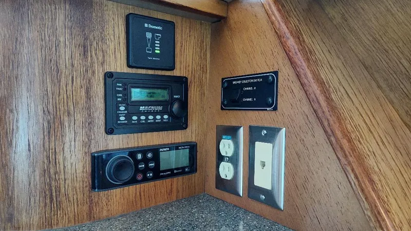 Epic Yacht Photos Pics Control panel of a 1998 Bayliner 4788 Pilothouse Motoryacht with various switches and outlets.