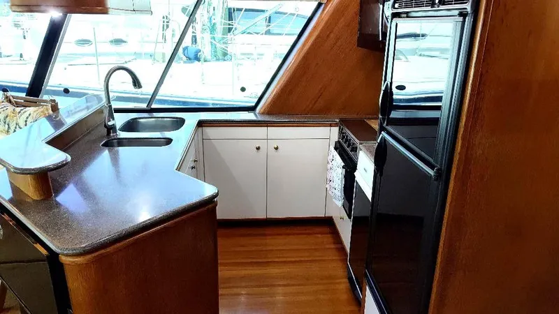 Epic Yacht Photos Pics Interior of 1998 Bayliner 4788 Pilothouse Motoryacht kitchen with modern appliances and wood finish.