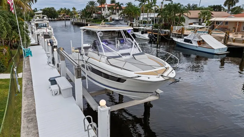  Yacht Photos Pics 2020 Jeanneau Leader 9.0 WA boat docked on a lift by a canal.