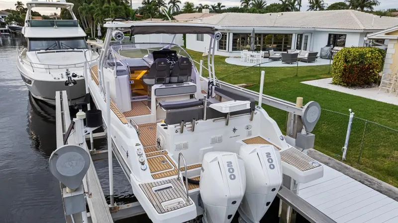  Yacht Photos Pics 2020 Jeanneau Leader 9.0 WA docked by waterfront home, featuring twin outboard engines.