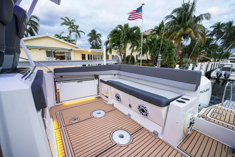  Yacht Photos Pics 2020 Jeanneau Leader 9.0 WA boat deck with seating, docked near palm trees and American flag.