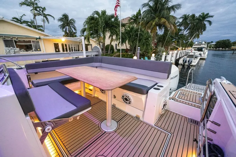  Yacht Photos Pics 2020 Jeanneau Leader 9.0 WA boat deck with seating and table, docked by palm trees.