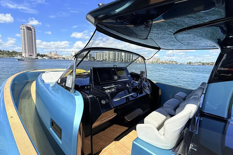  Yacht Photos Pics Luxurious 2022 Solaris Power 44 yacht interior with modern helm, overlooking scenic waterfront cityscape.