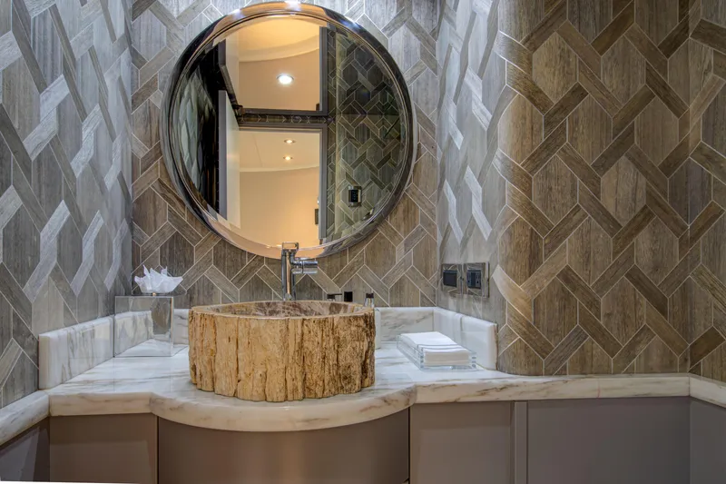 Spirit Yacht Photos Pics Luxurious bathroom vanity on Westport 112 yacht, featuring a round mirror and elegant stone sink.