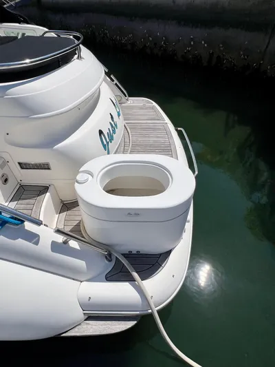  Yacht Photos Pics 1999 Fairline Targa 48 Open yacht with portable toilet on deck, docked in calm water.