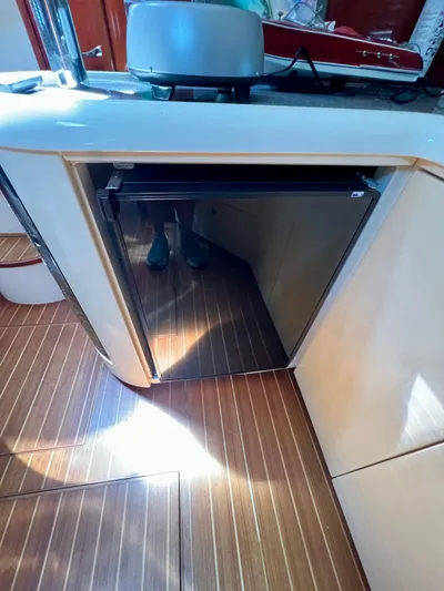  Yacht Photos Pics 1999 Fairline Targa 48 Open yacht interior with compact fridge and wooden flooring.