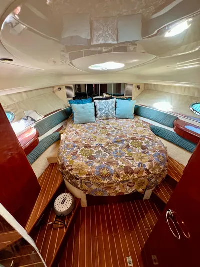  Yacht Photos Pics Cozy cabin interior of 1999 Fairline Targa 48 Open with floral bedding and wood flooring.