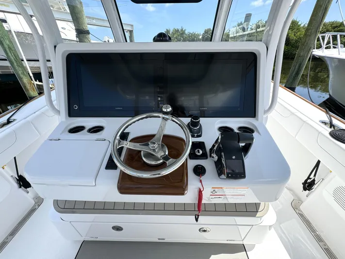  Yacht Photos Pics Helm of 2025 Phenom 37 boat with steering wheel and control panel.