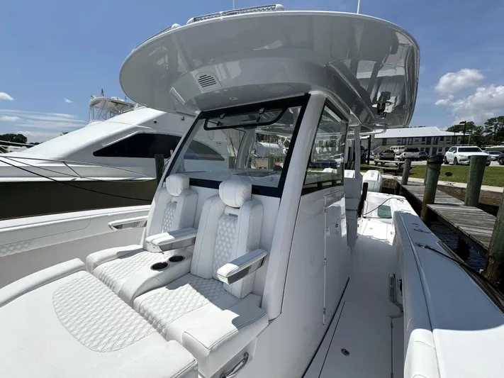  Yacht Photos Pics 2025 Phenom 37 boat with sleek white seating and modern design at a marina.