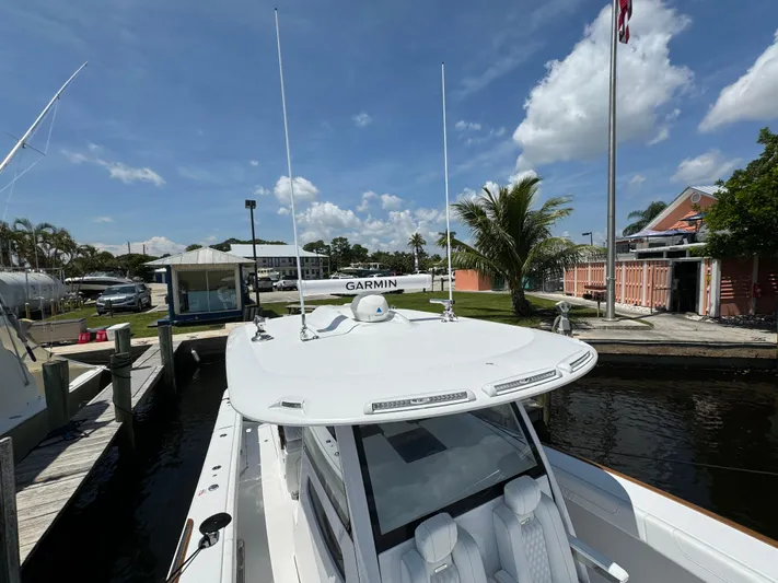  Yacht Photos Pics Phenom 37 boat docked, featuring advanced Garmin navigation, under a clear blue sky.