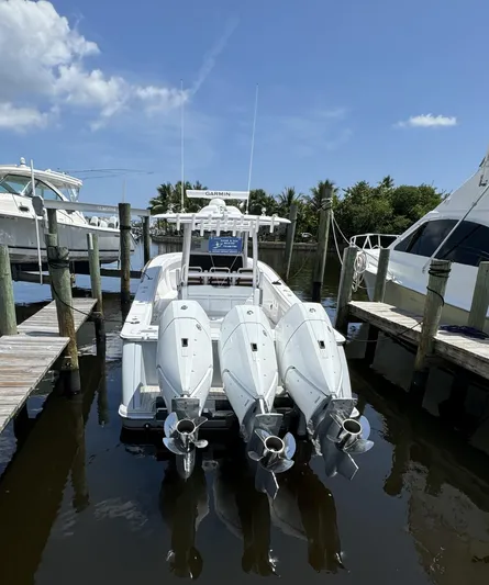  Yacht Photos Pics 2025 Phenom 37 boat docked with triple outboard engines under a clear blue sky.