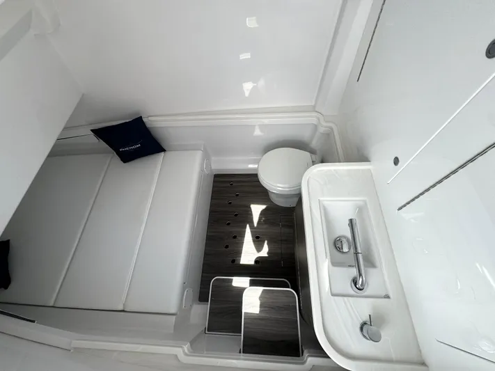  Yacht Photos Pics Modern bathroom in 2025 Phenom 37, featuring sleek sink, toilet, and cushioned bench.