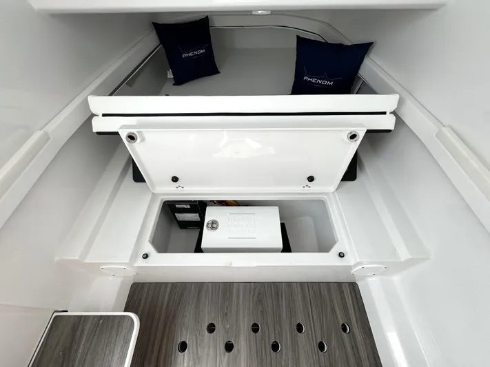  Yacht Photos Pics 2025 Phenom 37 interior storage compartment with cushions and wooden flooring.