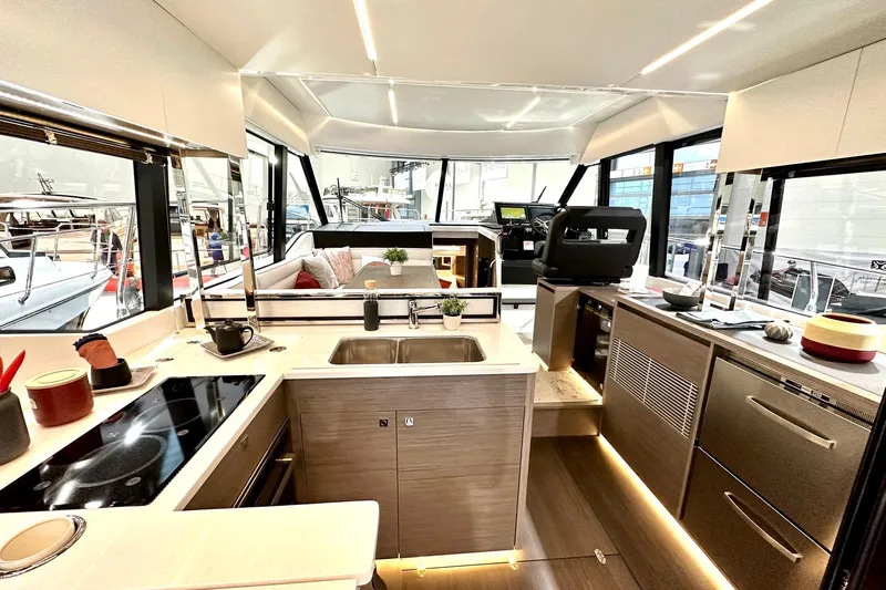  Yacht Photos Pics Luxurious interior of 2026 Jeanneau Merry Fisher 1295 Fly yacht with modern kitchen and seating area.