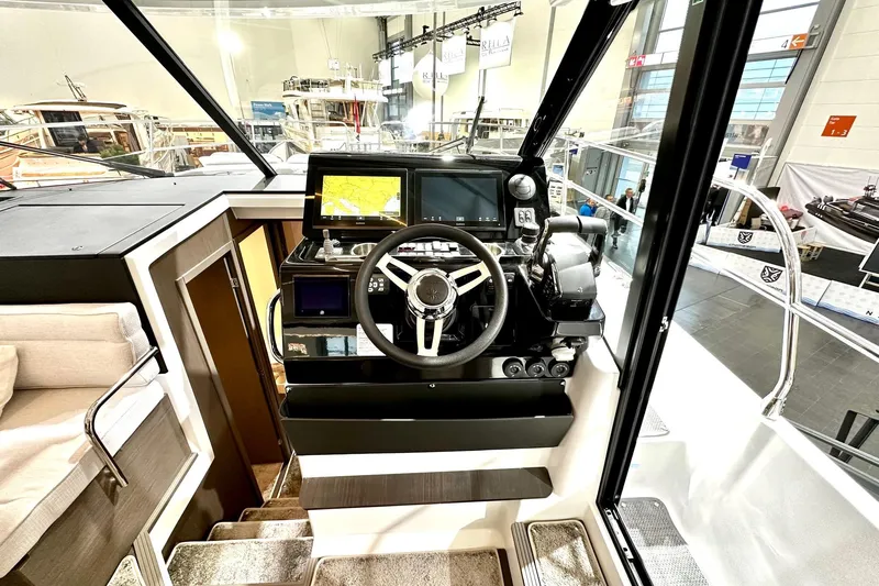  Yacht Photos Pics 2026 Jeanneau Merry Fisher 1295 Flybridge helm with modern navigation equipment and steering wheel.