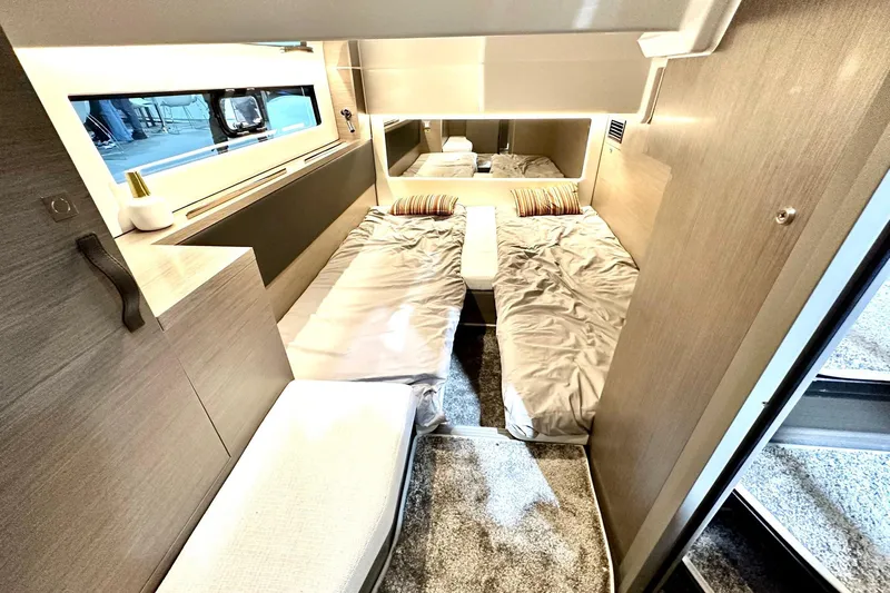  Yacht Photos Pics Interior cabin of 2026 Jeanneau Merry Fisher 1295 Fly, featuring twin beds and modern decor.