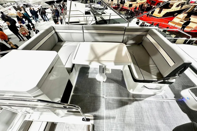  Yacht Photos Pics 2026 Jeanneau Merry Fisher 1295 Fly yacht interior with seating and table at a boat show.