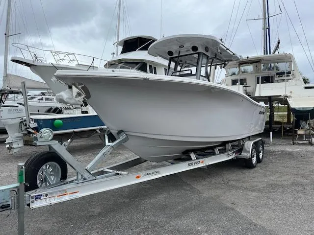 2025 Sea Pro 262 Sport boat on trailer at marina, surrounded by other boats.