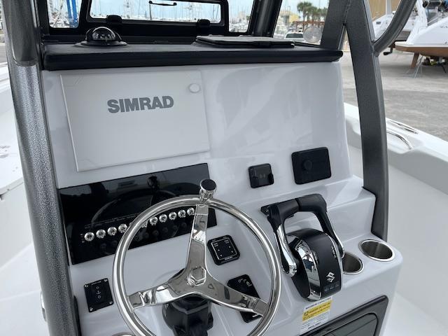 2025 Sea Pro 262 Sport boat dashboard with Simrad navigation system and steering wheel.