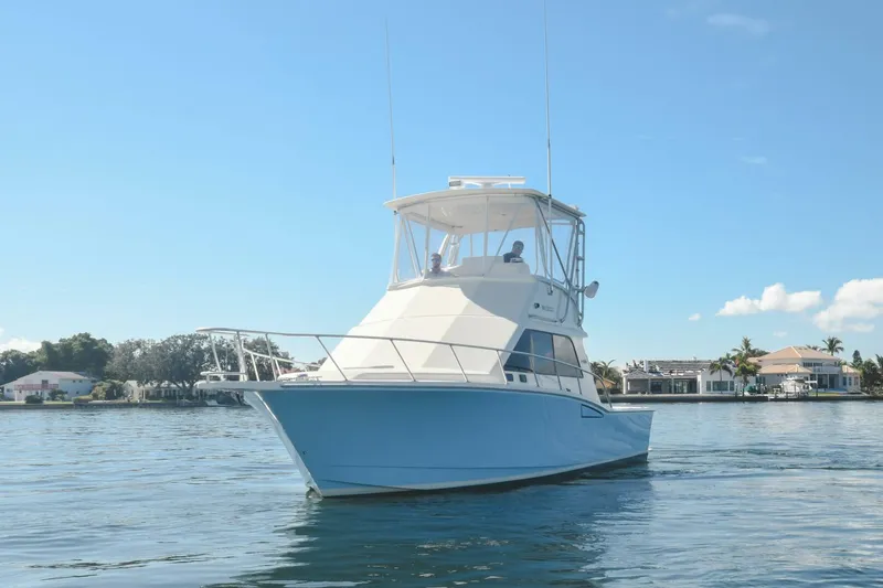 Vikingos Yacht Photos Pics 2001 Cabo 35 Flybridge boat on calm water with clear blue sky.
