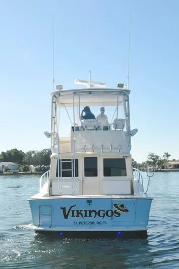 Vikingos Yacht Photos Pics 2001 Cabo 35 Flybridge boat on water, rear view.
