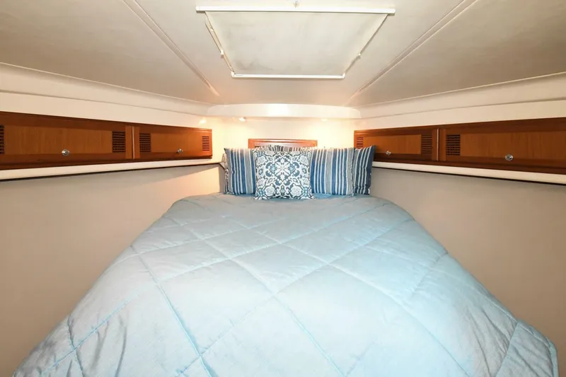 Vikingos Yacht Photos Pics Cozy cabin bedroom in a 2001 Cabo 35 Flybridge boat with blue bedding.