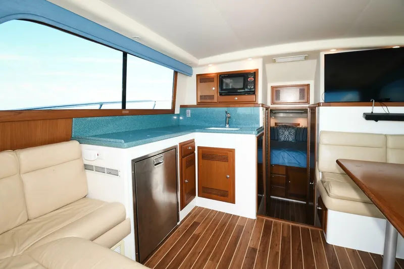 Vikingos Yacht Photos Pics Interior of 2001 Cabo 35 Flybridge yacht with kitchen and seating area.