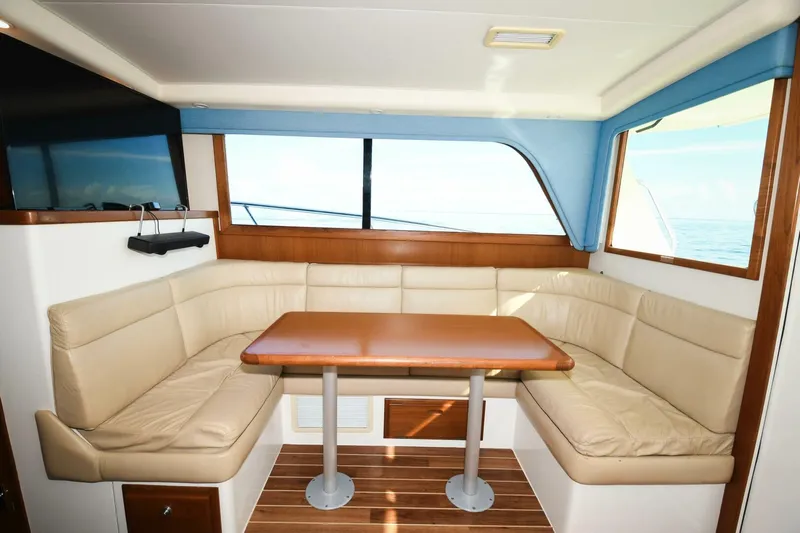 Vikingos Yacht Photos Pics Luxurious interior of 2001 Cabo 35 Flybridge with leather seating and wooden table.