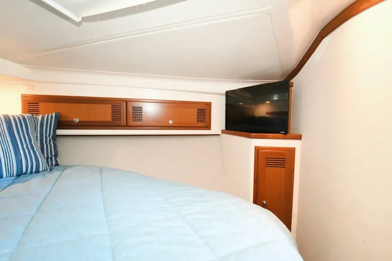 Vikingos Yacht Photos Pics Cabo 35 Flybridge 2001 cabin interior with bed, TV, and storage cabinets.