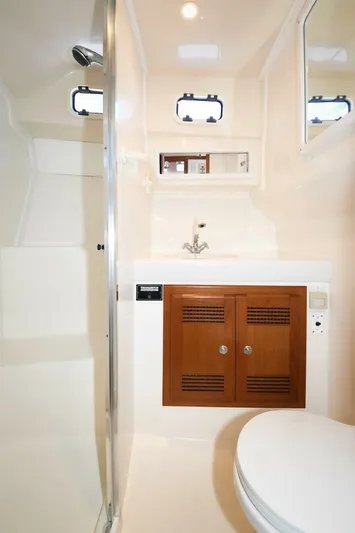 Vikingos Yacht Photos Pics 2001 Cabo 35 Flybridge bathroom with sink, wooden cabinet, and toilet.