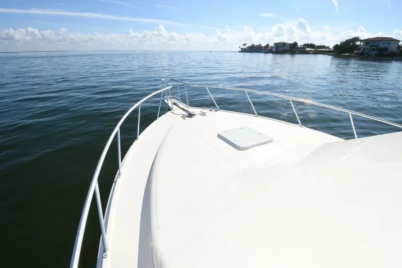 Vikingos Yacht Photos Pics 2001 Cabo 35 Flybridge boat cruising on calm waters near the shoreline.