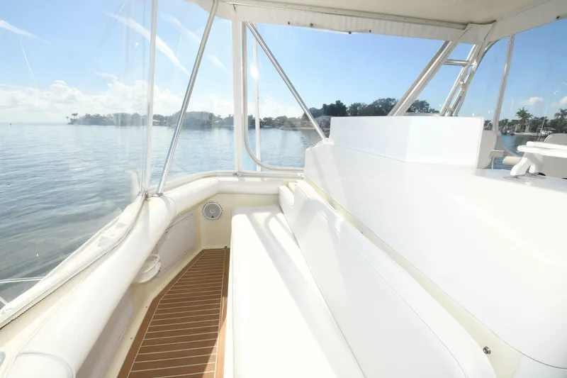 Vikingos Yacht Photos Pics Interior view of 2001 Cabo 35 Flybridge with white seating and clear windows.