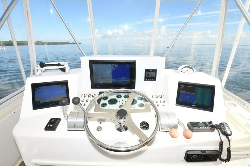 Vikingos Yacht Photos Pics Helm of 2001 Cabo 35 Flybridge with navigation screens and controls.