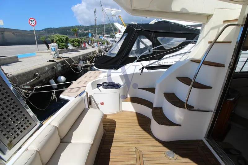 C Yacht Photos Pics 1999 Azimut 42 yacht docked, featuring elegant wooden deck and curved staircase.