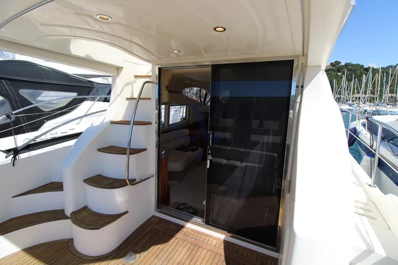 C Yacht Photos Pics 1999 Azimut 42 yacht with elegant interior and spiral staircase, docked at a marina.