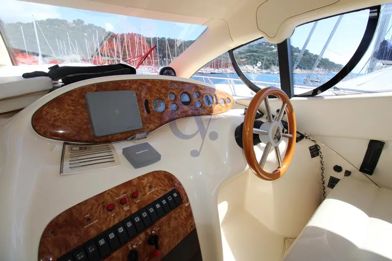 C Yacht Photos Pics 1999 Azimut 42 yacht helm with wooden steering wheel and control panel, overlooking marina.